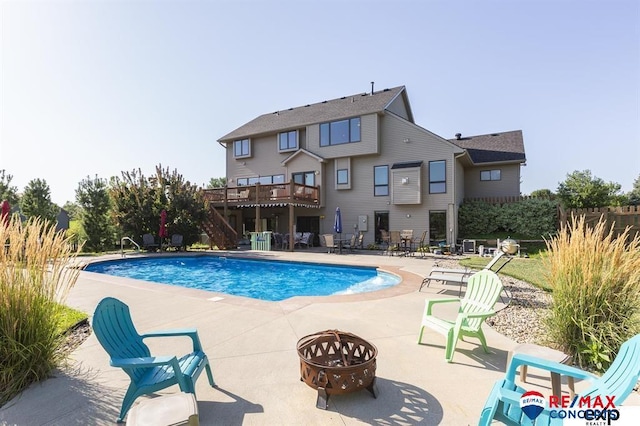 view of pool featuring a wooden deck, a patio, and a fire pit