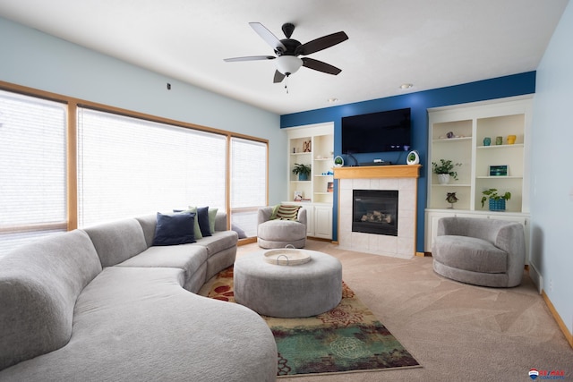 carpeted living room featuring built in shelves, ceiling fan, and a fireplace