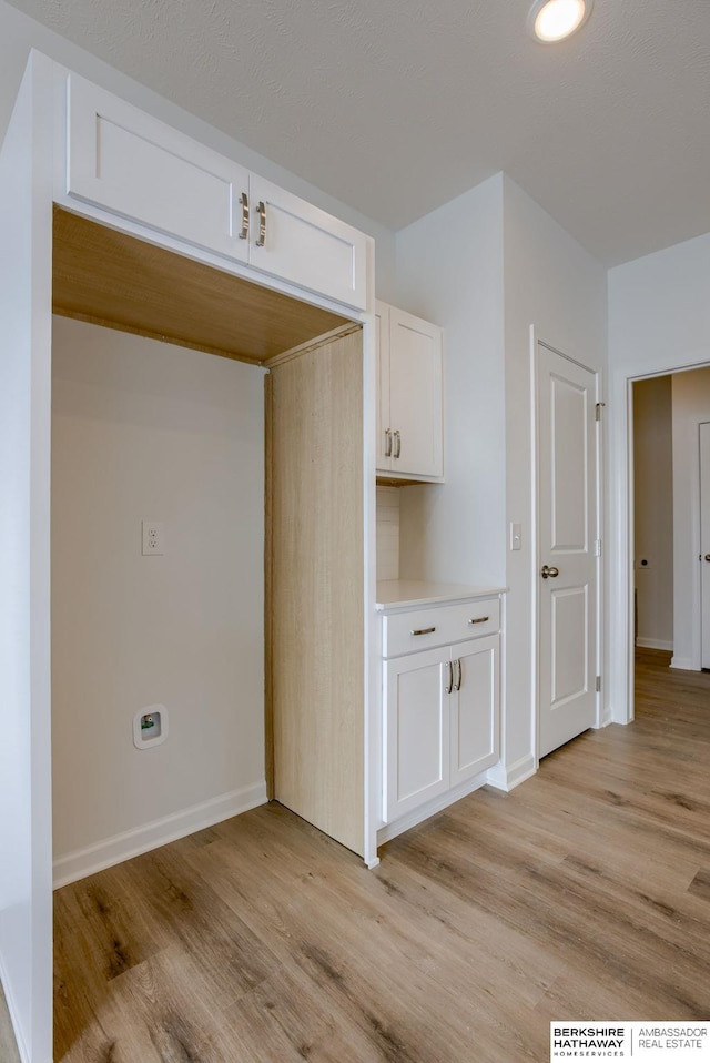 interior space with white cabinets and light hardwood / wood-style floors