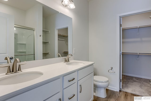 bathroom featuring hardwood / wood-style floors, vanity, toilet, and walk in shower