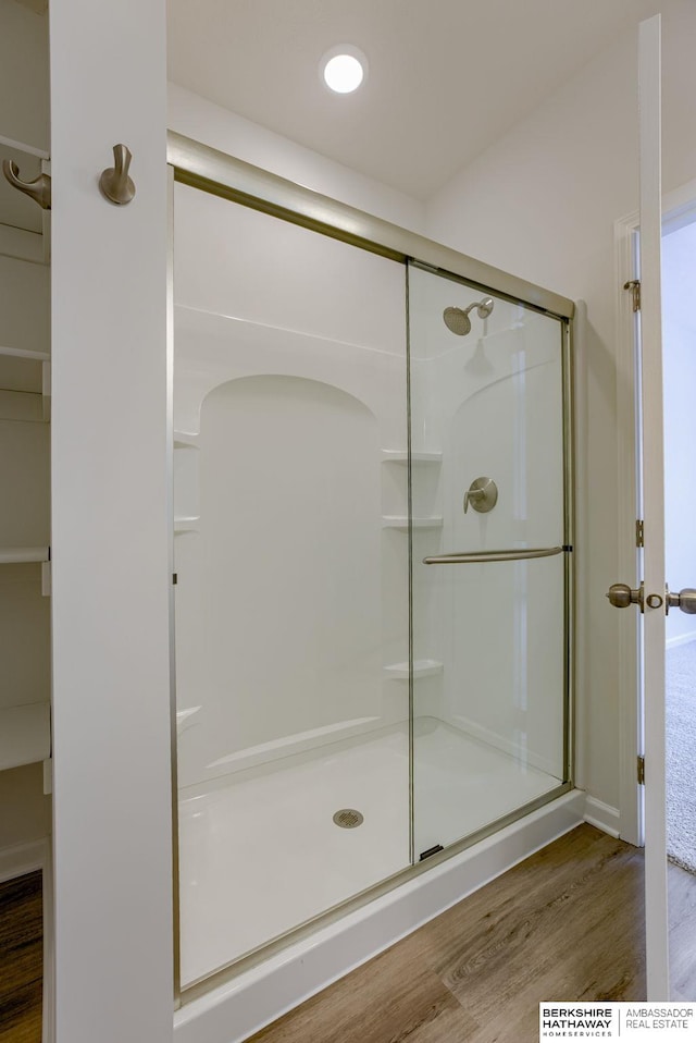 bathroom featuring wood-type flooring and a shower with shower door