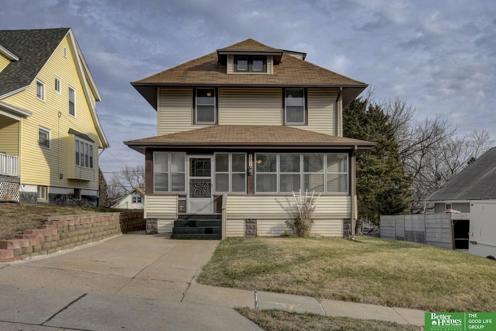 view of front of property with a front yard and a sunroom