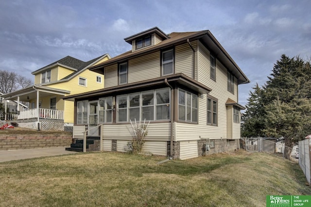 view of front facade with a sunroom and a front yard