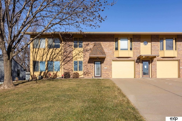 townhome / multi-family property featuring a garage and a front lawn