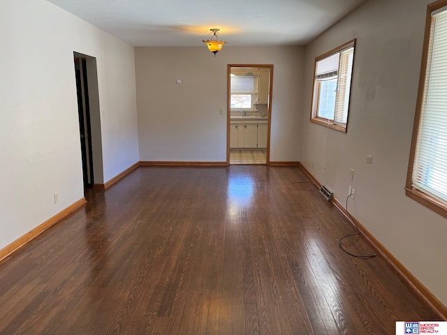 unfurnished room featuring dark wood-type flooring and sink