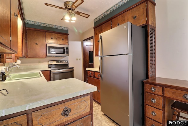 kitchen featuring kitchen peninsula, appliances with stainless steel finishes, ceiling fan, and sink