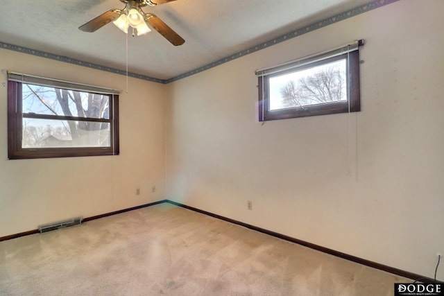 carpeted spare room with ceiling fan and a healthy amount of sunlight