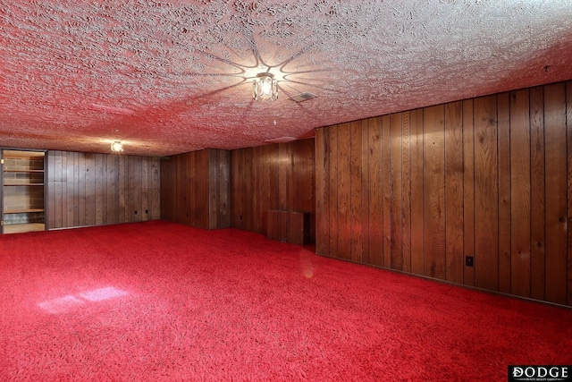 basement featuring carpet flooring and wood walls