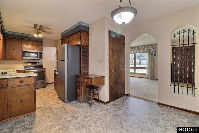 kitchen featuring ceiling fan, sink, and stainless steel appliances