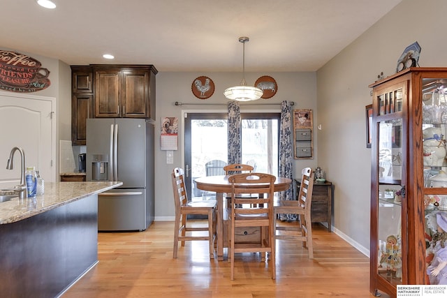 dining room with light hardwood / wood-style floors and sink