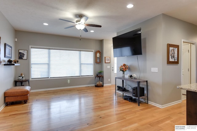 living room with ceiling fan and light wood-type flooring