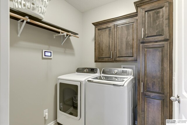 laundry room featuring separate washer and dryer and cabinets