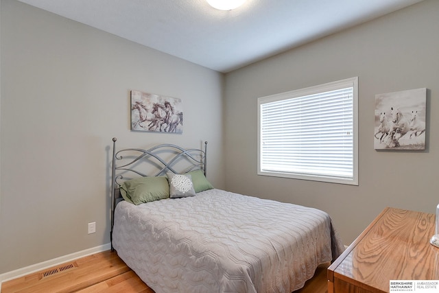 bedroom featuring multiple windows and light hardwood / wood-style floors