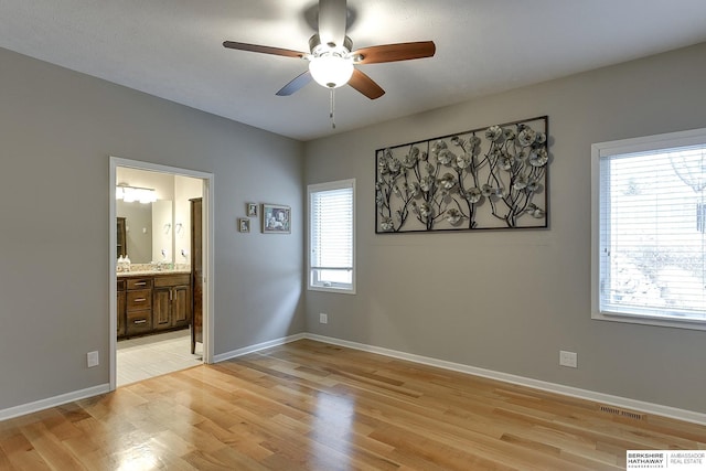 unfurnished bedroom with ensuite bathroom, light hardwood / wood-style flooring, and ceiling fan