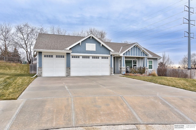 craftsman house with covered porch, a garage, and a front lawn