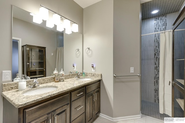 bathroom featuring tile patterned flooring, vanity, and curtained shower