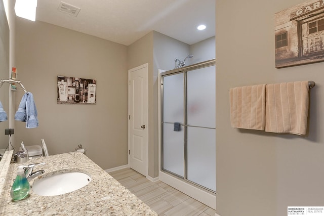 bathroom featuring vanity and a shower with shower door