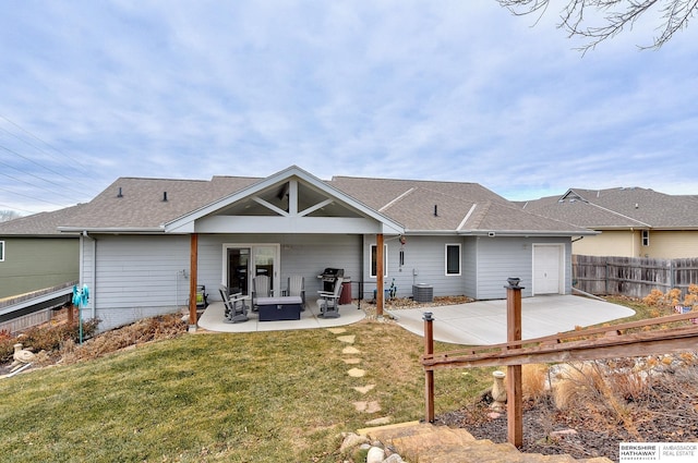 back of property with a lawn, central air condition unit, and a patio