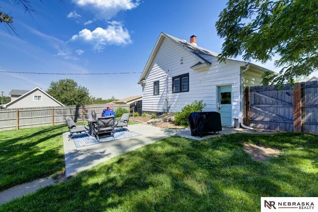 back of house with a lawn and a patio