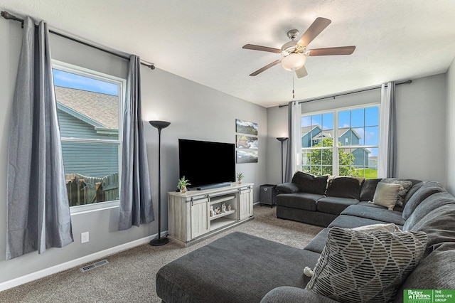 living room with a healthy amount of sunlight, ceiling fan, and light colored carpet