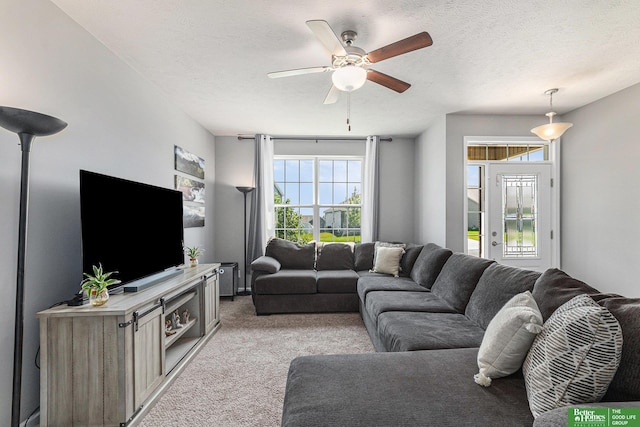 carpeted living room featuring a textured ceiling and ceiling fan