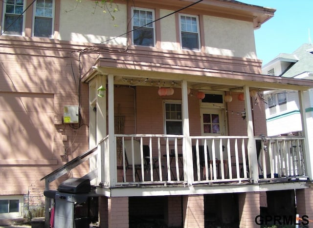 rear view of house featuring covered porch