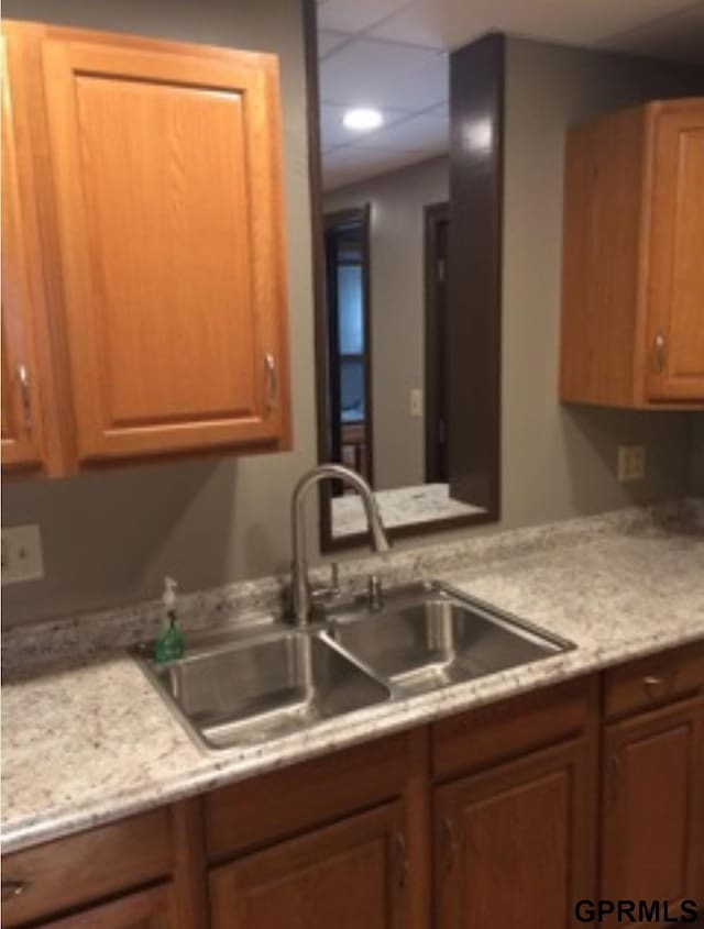 kitchen featuring light stone countertops and sink