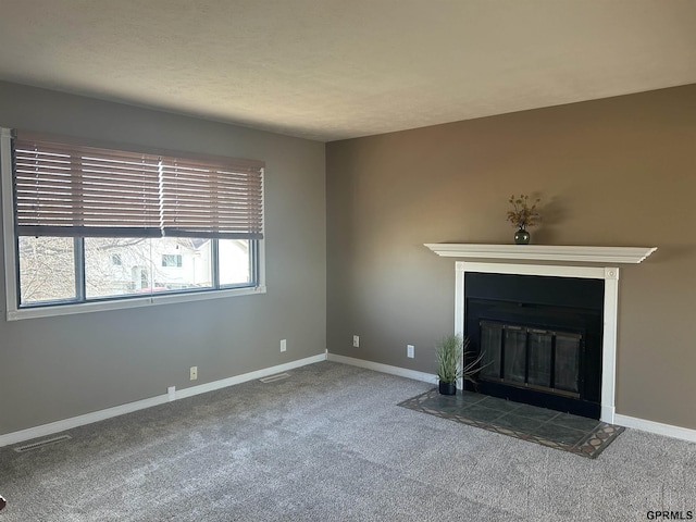 unfurnished living room with a tile fireplace and carpet flooring