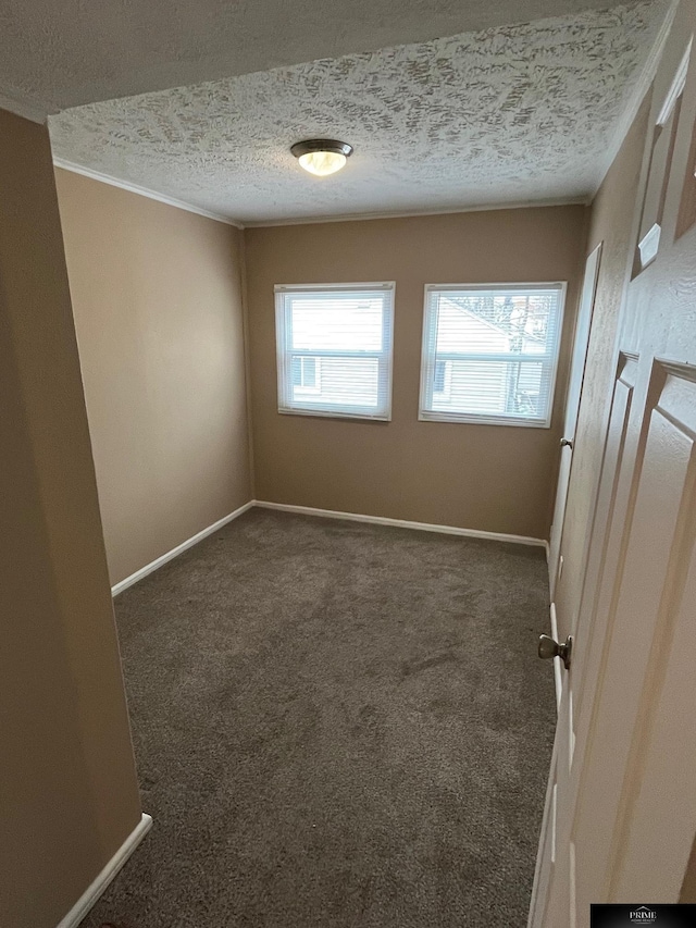 unfurnished room with dark colored carpet and a textured ceiling