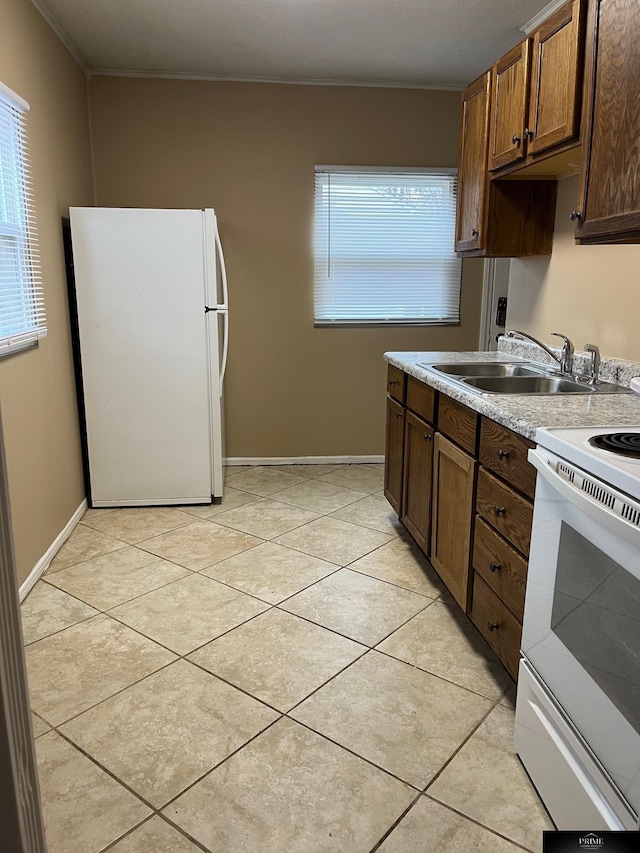 kitchen featuring light tile patterned floors, white appliances, a wealth of natural light, and sink