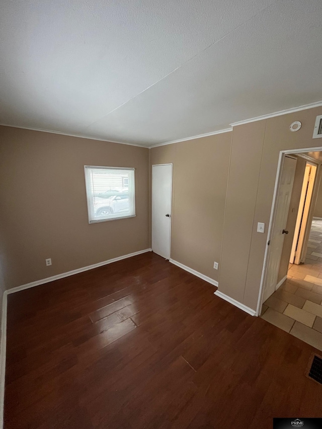 unfurnished room featuring dark hardwood / wood-style flooring and crown molding