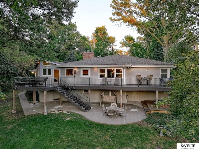 rear view of property with a yard, a patio, and a deck