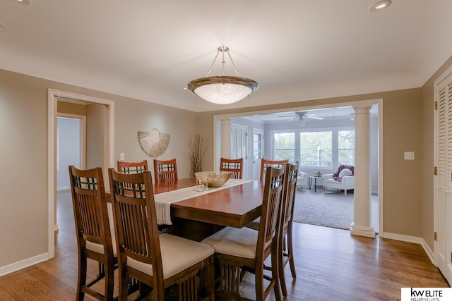 dining room with hardwood / wood-style floors, ceiling fan, and ornate columns