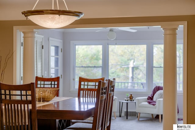 carpeted dining room with decorative columns