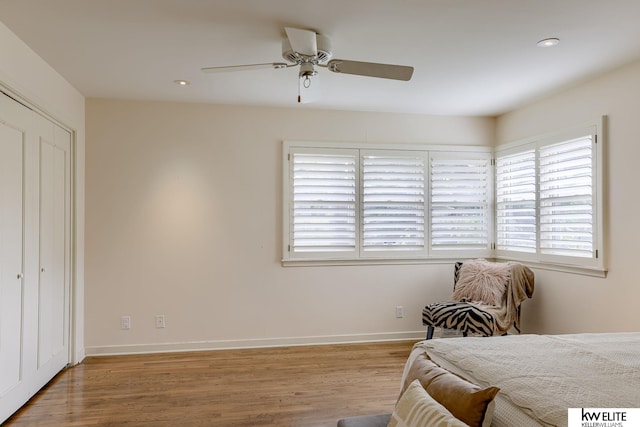 bedroom with ceiling fan, light hardwood / wood-style flooring, and a closet