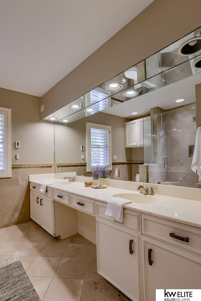 bathroom featuring walk in shower, vanity, tile patterned floors, and tile walls