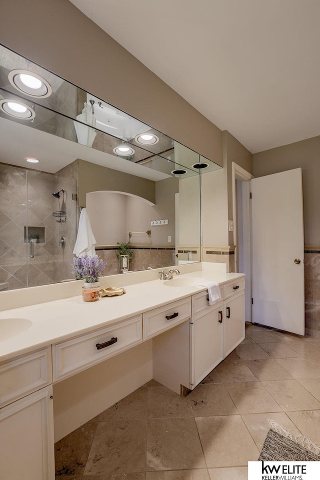 bathroom with a shower with door and vanity