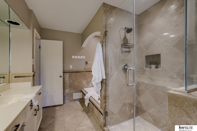 bathroom with vanity, separate shower and tub, and tile walls