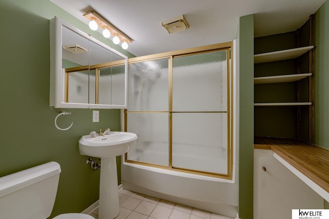 full bathroom featuring tile patterned flooring, toilet, combined bath / shower with glass door, and sink