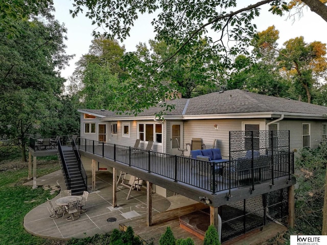 back of house with outdoor lounge area, a patio, and a deck