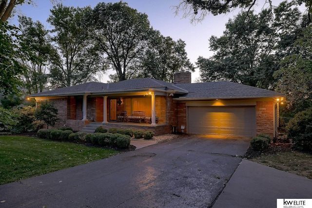 prairie-style house featuring a garage and a yard