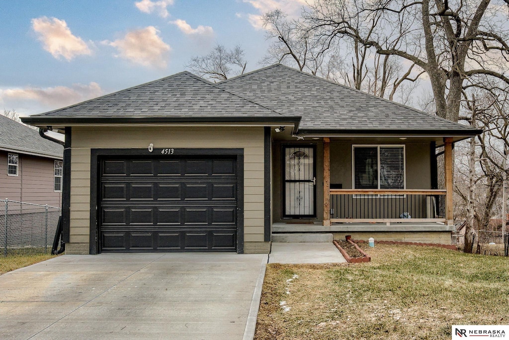 single story home featuring a garage, covered porch, and a front lawn