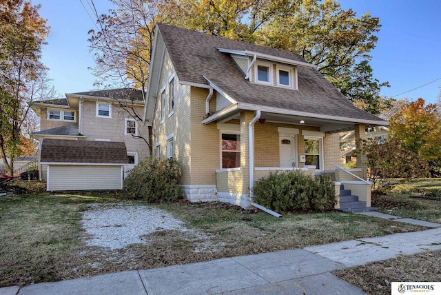 bungalow-style home featuring covered porch and a front yard