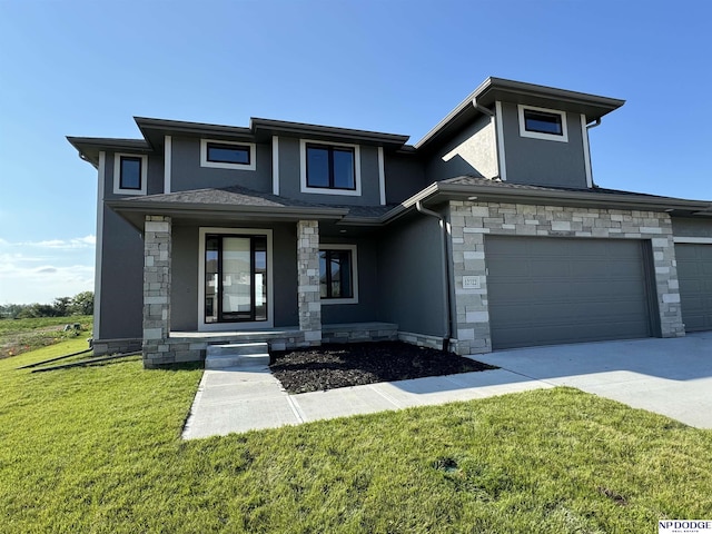 prairie-style house featuring a garage and a front yard