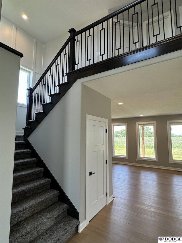 stairs with wood-type flooring and plenty of natural light