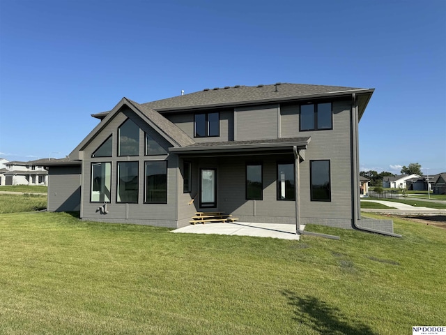 rear view of house featuring a patio area and a yard