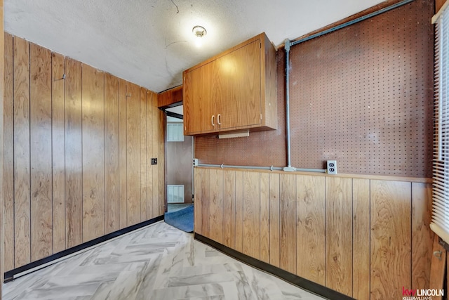 kitchen with wooden walls and a textured ceiling