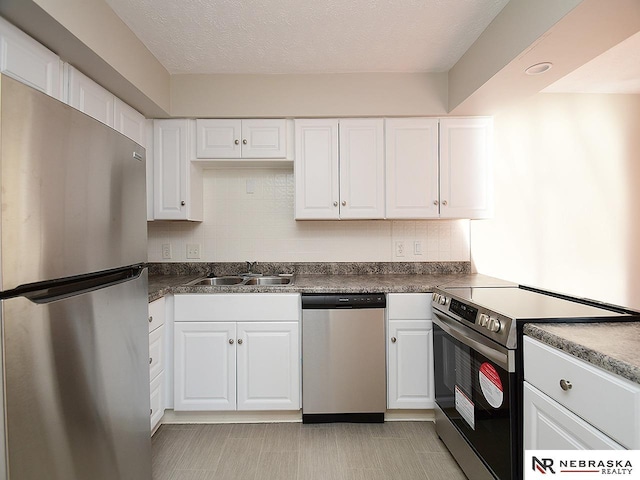 kitchen with white cabinetry, sink, a textured ceiling, and appliances with stainless steel finishes