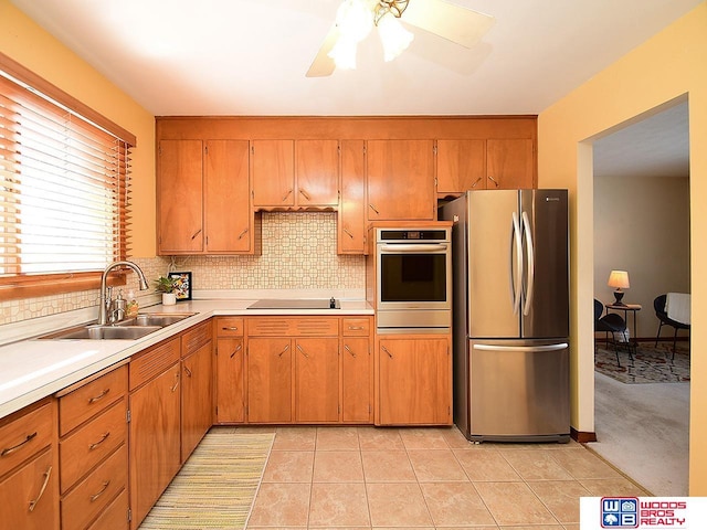 kitchen featuring ceiling fan, sink, tasteful backsplash, light tile patterned flooring, and appliances with stainless steel finishes