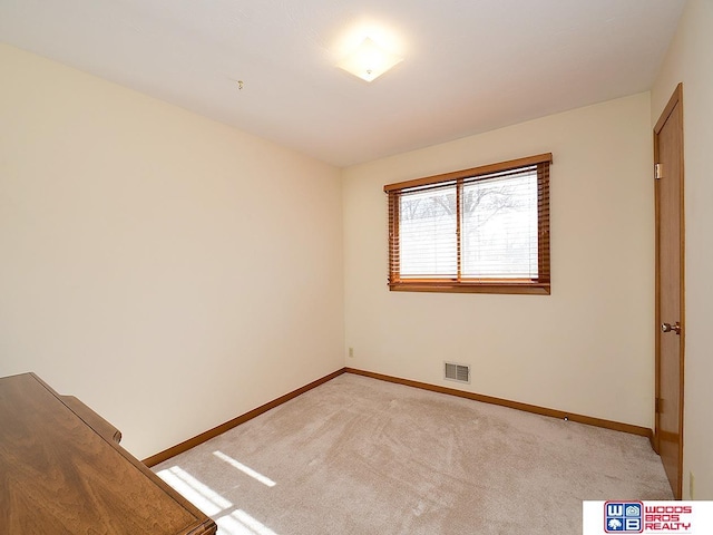 spare room featuring light colored carpet